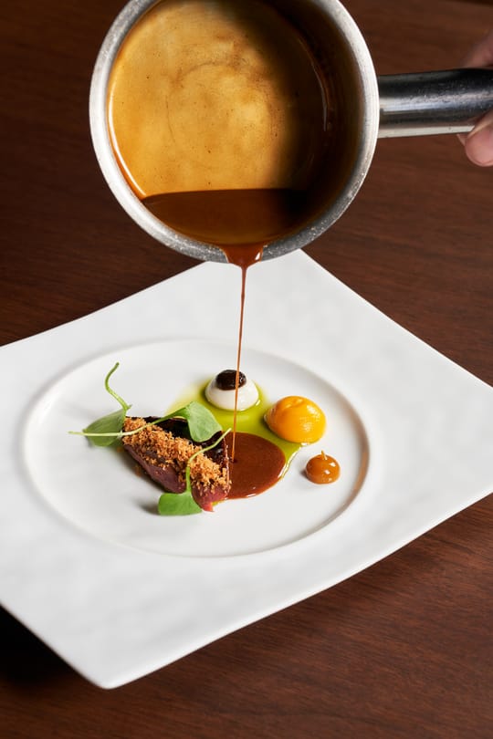 Vlees met gelakte jus, aan tafel opgegoten